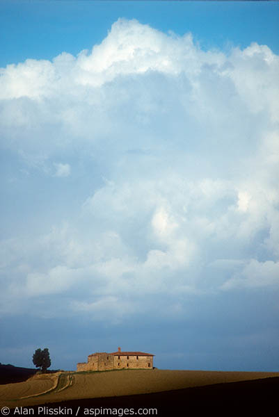 A storm cloud clears over a Tuscany farmhouse.