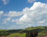 The green hills of northern Marin framed with cumulus clouds.