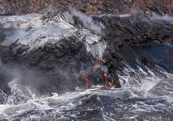 The lower land formed the previous week was created by the lava flow in the image with the boat.  The eruption of Mauna Loa over the past 3 decades has added hundreds of acres of land to the Big Island, Hawaii.