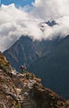 A distant mountain breaks through the clouds as this hiker reaches a crest in the trail.