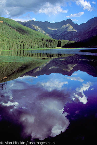 Cumulus cloud reflects in this Rocky Mountain lake near Vail, Colorado.